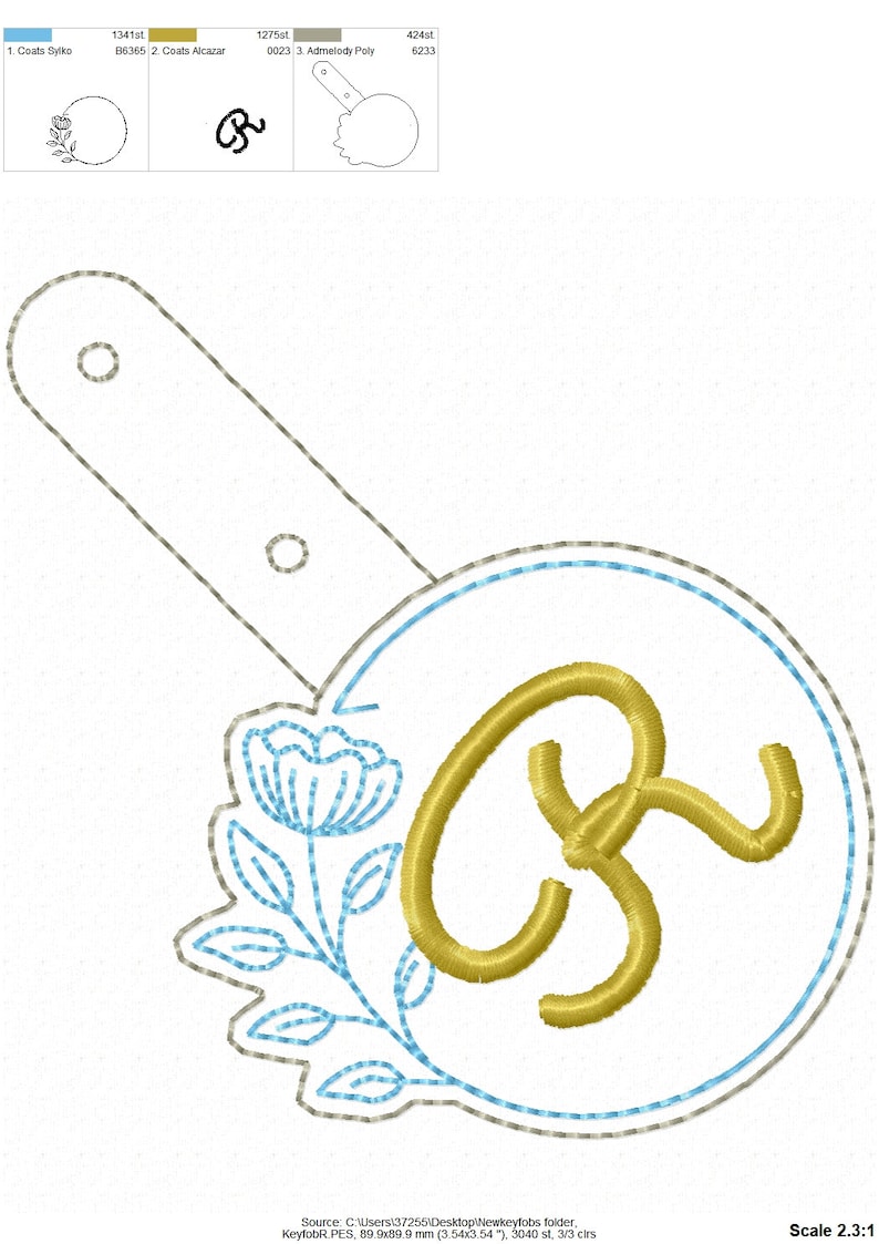 May include: A gold embroidered letter "R" with a blue floral design in a circle. The circle is attached to a gray strap.