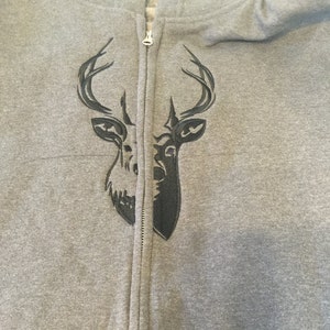 May include: A gray zippered hoodie with a black embroidered deer head design on the front.