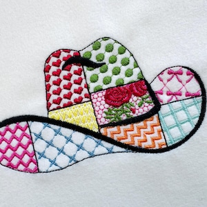 May include: A colourful patchwork cowboy hat with a black outline. The hat is made up of different coloured squares with various patterns, including hearts, polka dots and chequered designs.