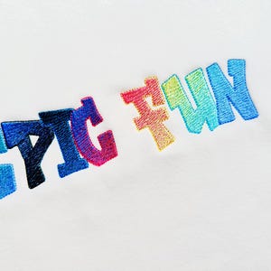 Puede incluir: Fondo blanco con la frase bordada "EPIC FUN" en un diseño colorido y degradado. Las letras, en una fuente de estilo burbuja, transicionan a través de tonos de azul, rosa, amarillo y verde, creando un efecto arcoíris.