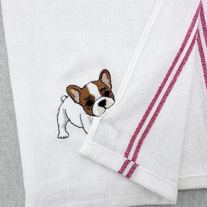 Könnte beinhalten: Weißes Küchentuch mit einem gestickten braunen und weißen French Bulldog. Das Handtuch hat zwei vertikale burgunderfarbene Streifen und einen gefalteten Rand. Das Handtuch ist aus einem strukturierten Stoff.