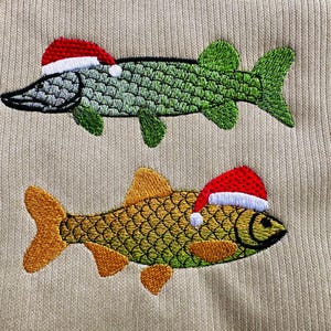 May include: Two embroidered fish wearing Santa hats. The top fish is green and the bottom fish is yellow.