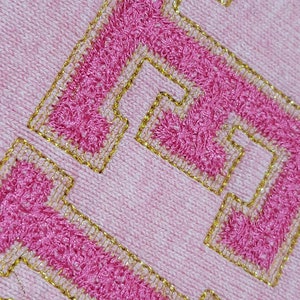 May include: Pink sweatshirt with a gold embroidered "LOVE" on the front.