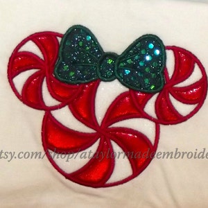 May include: Red and white candy cane shaped embroidery design with a green sparkly bow. Etsy.com/shop/ataylormadeembroider