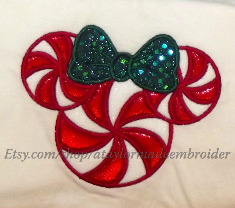 May include: Red and white candy cane shaped embroidery design with a green sparkly bow. Etsy.com/shop/ataylormadeembroider