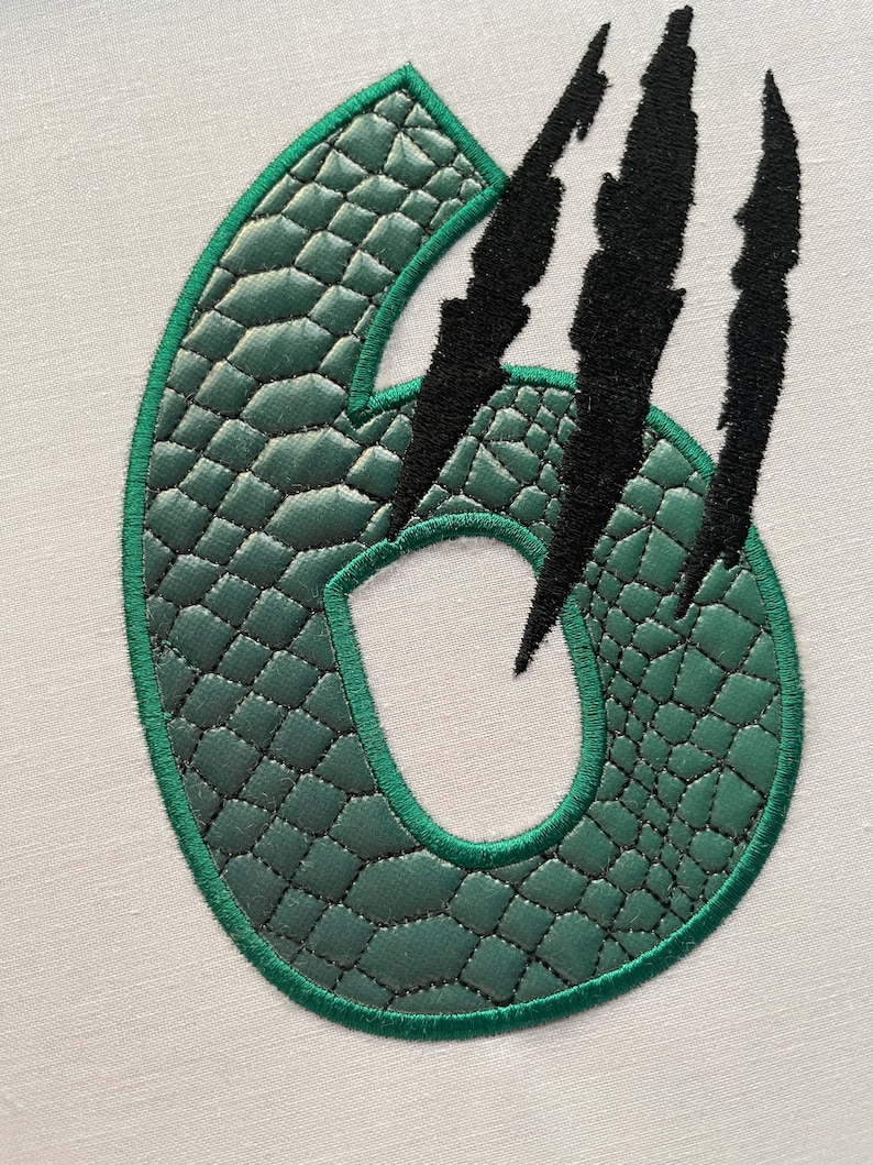 May include: Green number six with a textured, scaly surface, surrounded by three black claw marks.
