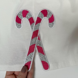 May include: White fabric with a pink and silver candy cane applique.