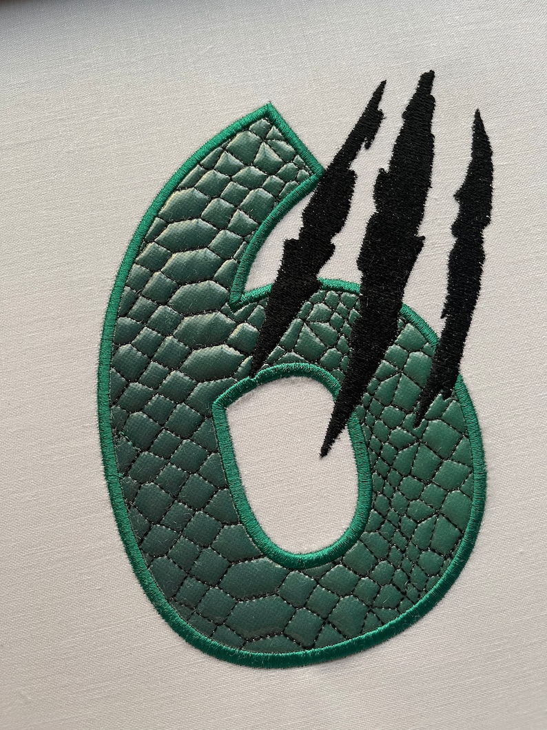 May include: Green number six with a crocodile skin texture and black claw marks.
