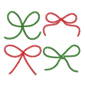 May include: Four decorative bows made of green and red beads. The bows are arranged in a square pattern.
