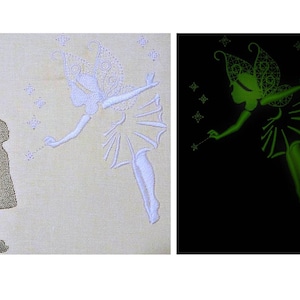 May include: A white embroidered fairy with wings and a wand, glowing green in the dark, with a small girl silhouette in the background.