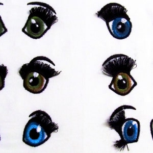 May include: Nine embroidered felt doll eyes with eyelashes. Three pairs of eyes are green, three pairs are brown, and three pairs are blue.