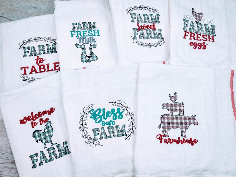 May include: Set of 7 white kitchen towels with red and teal checked designs and embroidered text. The text includes "Farm to Table", "Farm Fresh Milk", "Farm Sweet Farm", "Farm Fresh Eggs", "Welcome to the Farm", "Bless Our Farm", and "Farmhouse".
