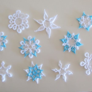 以下が含まれることがあります： 青いアクセントが付いた白い雪の結晶のオーナメントが10個。雪の結晶のデザインは、それぞれ異なります。