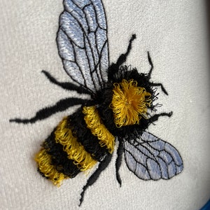 May include: Embroidered bumble bee with black and yellow stripes and translucent blue wings.