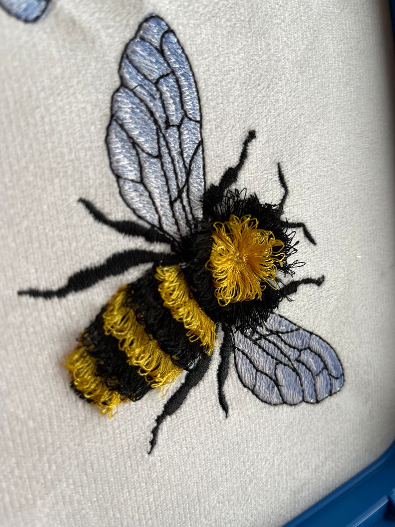May include: Embroidered bumble bee with black and yellow stripes and translucent blue wings.