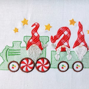 May include: Three gnomes riding on a green train with candy cane wheels. The gnomes are wearing red and white hats and have white beards. There are yellow stars in the background.