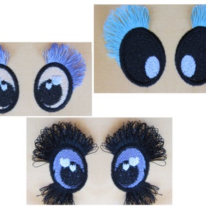 Puede incluir: Tres pares de ojos de fieltro bordados con pestañas de diferentes colores. El primer par tiene pestañas azul claro, el segundo par tiene pestañas moradas y el tercer par tiene pestañas negras. Cada ojo tiene una pupila blanca y un iris negro.
