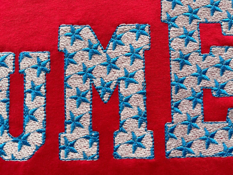 May include: Red fabric with the word "SUMMER" embroidered in white thread with blue star-shaped accents.
