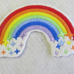 May include: A rainbow-colored embroidered patch with a white background and stars. The rainbow is made of red, orange, yellow, green, blue, indigo, and violet. The stars are white, yellow, orange, and blue.