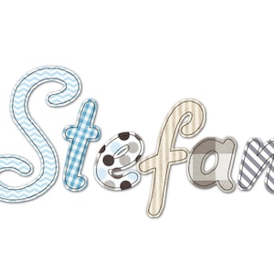 May include: The name "Stefan" in a whimsical, patchwork style. Each letter is a different pattern, including blue chevron, gingham, polka dots, stripes, and a plaid design. The letters are outlined with a black stitch.