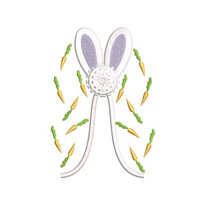May include: White bunny ears with a purple center and a white circle with a floral design.  The ears are surrounded by a ring of small orange carrots with green tops.