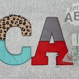 Könnte beinhalten: Nahaufnahme der Buchstaben "C" und "A", die aus Stoffresten hergestellt wurden. Der Buchstabe "C" besteht aus einem Leopardenmusterstoff, einem türkisfarbenen Stoff und einem schwarzen Stoff. Der Buchstabe "A" besteht aus einem grauen Stoff, einem roten Stoff und einem schwarzen Stoff. Die Buchstaben sind zusammengenäht und befinden sich auf einem grauen Hintergrund. Der Text "Entire ABC" ist in der oberen rechten Ecke des Bildes sichtbar.