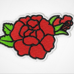 May include: A red embroidered rose with green leaves. The rose is outlined in black and has a textured appearance.