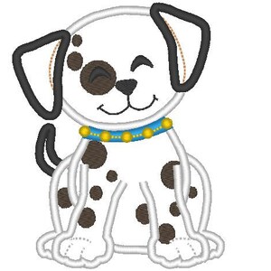 Op de afbeelding: Een wit-zwarte dalmati&euml;r puppy met bruine ogen en een blauwe halsband met gouden kralen. De puppy zit met gekruiste poten en heeft een gelukkige uitdrukking op zijn gezicht.