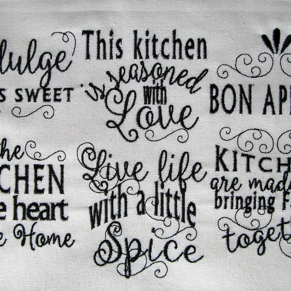 May include: Black and white embroidered kitchen towel with the text "Indulge Life is Sweet", "This kitchen is seasoned with Love", "Bon Appetit", "The Kitchen is the heart of the Home", "Live life with a little Spice", and "Kitchens are made for bringing families together".