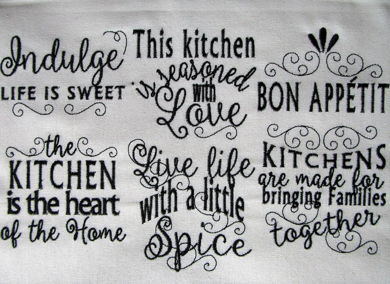May include: Black and white embroidered kitchen towel with the text "Indulge Life is Sweet", "This kitchen is seasoned with Love", "Bon Appetit", "The Kitchen is the heart of the Home", "Live life with a little Spice", and "Kitchens are made for bringing families together".