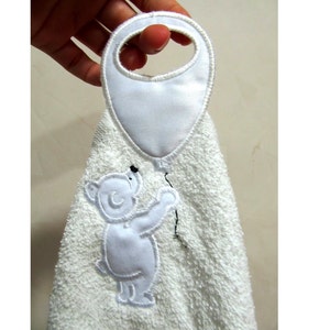 Peut inclure: Serviette de toilette en tissu éponge blanc avec un ours polaire brodé en blanc tenant un ballon. La serviette a une boucle pour l'accrocher.
