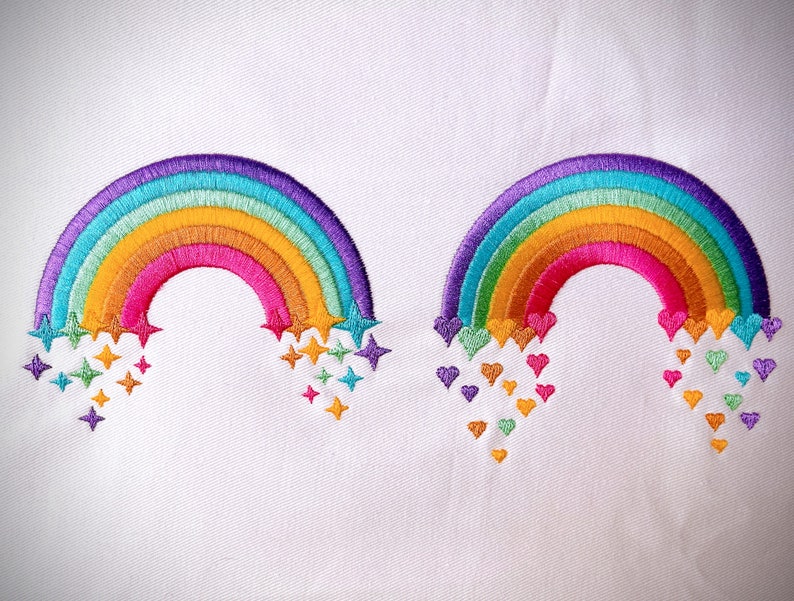 May include: Two embroidered rainbows with different embellishments. One rainbow has stars falling from it, the other has hearts.