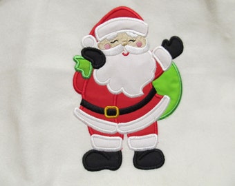 Puede incluir: Diseño bordado de Santa Claus con un traje rojo, barba blanca y bolsa verde. El diseño está sobre un fondo blanco.