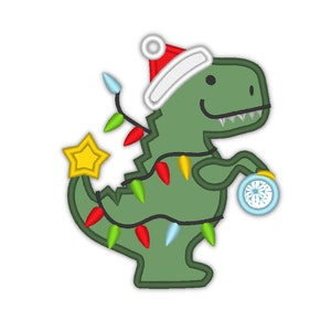 Puede incluir: Un dinosaurio verde con un gorro de Papá Noel rojo y blanco está decorado con luces de Navidad de colores. El dinosaurio sostiene un adorno azul con un diseño de copo de nieve.