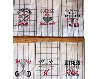 May include: Set of six white kitchen towels with black and green plaid borders. Each towel features a different embroidered design with red hearts and text. The designs include "The Main Ingredient is Love", "With Coffee Anything is Possible", "This Home Runs on Love Laughter and Wine", "Whip it Whip it Good", "Just Roll With It", and "The Kitchen is the Heart of the Home".