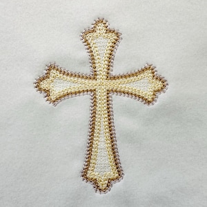 May include: A white embroidered cross with a gold outline.