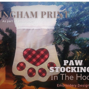 Peut inclure: Une chaussette blanche avec un motif de patte d'animal en gingham rouge et noir. La chaussette a un imprimé gingham en forme de cœur au centre. Le texte "PAW STOCKINGS In The Hoop" est sous la chaussette. Le texte "Embroidery Designs" est sous le texte principal. Le texte "GINGHAM PRINT As part of embroidery" est en haut de l'image.