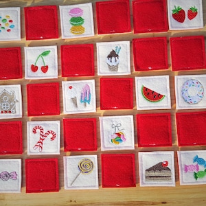 May include: A set of 20 felt squares with various embroidered images of sweets and treats. The squares are white with red felt backing. The images include a gingerbread house, candy canes, a doughnut, a watermelon slice, a cupcake, a lollipop, a cake, and more.