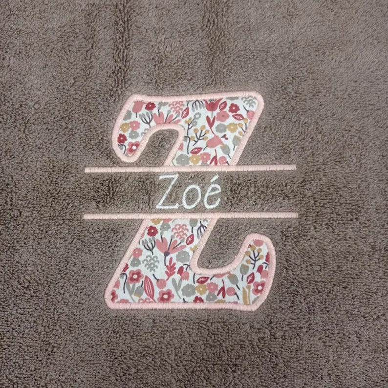 May include: A brown plush blanket with a pink floral embroidered letter Z and the name "Zo&eacute;" embroidered in white.