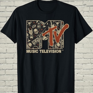 May include: Black t-shirt featuring the MTV logo in a retro design. The logo is filled with music-themed illustrations, including skulls, guitars, and cassette tapes. The words "MUSIC TELEVISION" are printed below the logo.