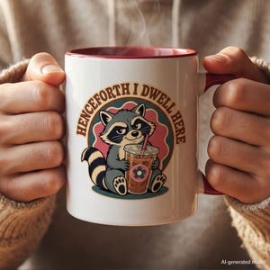 May include: A white ceramic mug with a red interior and handle, featuring a graphic of a raccoon holding an iced coffee. The text "HENCEFORTH I DWELL HERE" is printed in a circular brown font around the raccoon, which is set against a pink and teal background.