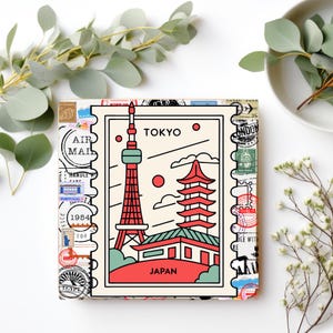 May include: A cream-coloured square print with a stylized illustration of Tokyo, Japan. The design features the Tokyo Tower and a traditional pagoda, with the word "TOKYO" at the top. The print is surrounded by postage stamp designs and the words "AIR MAIL".
