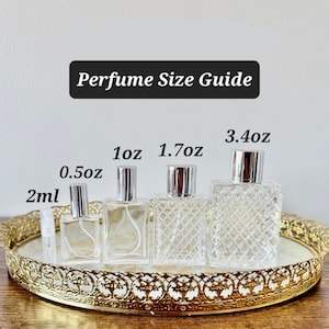 May include: A perfume size guide featuring various clear glass perfume bottles with silver sprayers. The bottles range in size from 2ml to 3.4oz, displayed on a gold-colored decorative tray. The text "Perfume Size Guide" is at the top.