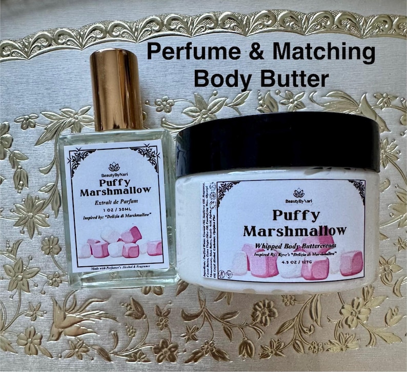 May include: A perfume bottle and a jar of body butter with the text "Puffy Marshmallow". The perfume bottle has a gold cap and a label with the text "Extrait de Parfum". The body butter jar has a black lid and a label with the text "Whipped Body Buttercream".