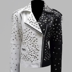 May include: A two-tone leather jacket, split vertically in half with white and black panels. The jacket is adorned with silver studs and spikes on the shoulders. Features a zipper closure and a small pocket on the white side.