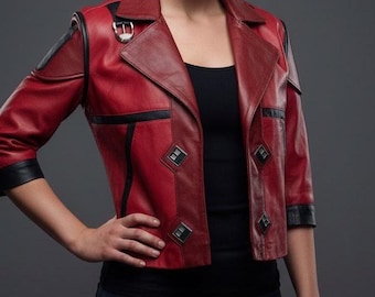 May include: A red leather jacket with black accents. The jacket features a notched collar, three-quarter sleeves, and diamond-shaped embellishments. A silver buckle secures the collar. The jacket is worn over a black top.