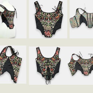 Op de afbeelding: Een collectie zwarte korsetten met bloemenborduurwerk in rood, groen en goud. De korsetten hebben verschillende bandjes en strikdesigns, die een reeks stijlen laten zien. De stof lijkt een mix van satijn en geborduurd materiaal te zijn.