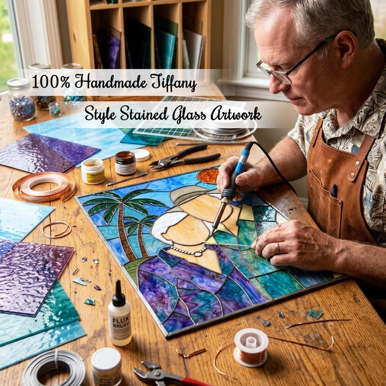 May include: A square stained glass artwork featuring a stylized couple under palm trees, being soldered with a blue tool. The piece displays blue, purple, and green glass segments. Text reads: 100% Handmade Tiffany Style Stained Glass Artwork.