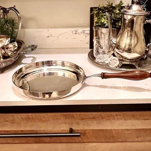 May include: A white ceramic mug with a black handle and the text "But First, Coffee" in a black, handwritten-style font. The mug sits on a white surface.