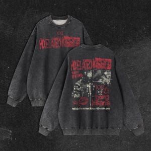 Könnte beinhalten: Zwei anthrazitfarbene Sweatshirts mit langen Ärmeln. Auf der Vorderseite des Sweatshirts steht in Rot der Text "PIXELATED KISSES". Auf der Rückseite des Sweatshirts steht derselbe Text, eine Grafik und der Text "replace the moment from a million miles away."